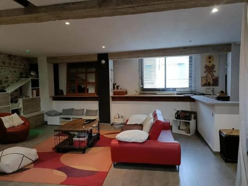 un salon avec un canapé rouge et une table dans l'établissement Appartement spacieux à Saint-Jean-Lasseille avec vue sur montagne, à Saint-Jean-Lasseille