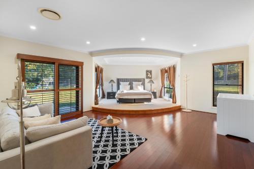 a large bedroom with a bed and a living room at Luxury Range Stay! 6 Bedroom 4 Bathroom in Thornlands