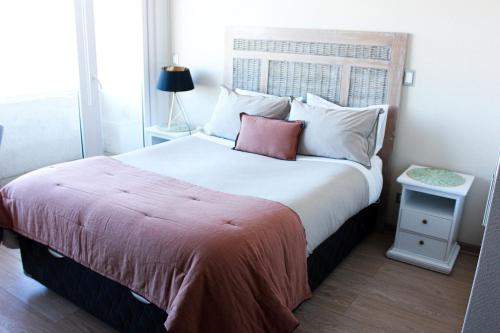 a bedroom with a large bed with a red blanket at Acogedor Departamento estudio en centro de Chillán in Chillán
