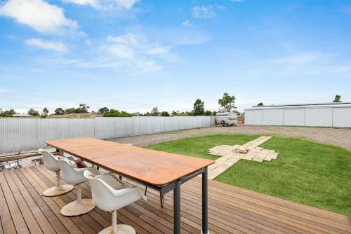 a wooden deck with a wooden table and chairs at The White House in Wellington East
