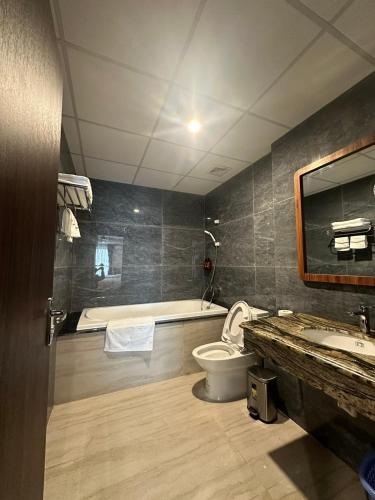 a bathroom with a tub and a toilet and a sink at ATOUR Phoenix Hotel in Bắc Ninh
