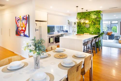 a kitchen and living room with a table and chairs at Private Family City Retreat, Sleeps 8 in Christchurch