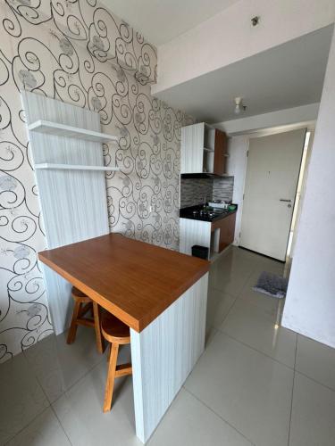 a kitchen with a wooden table in a room at Apartment Anderson Benson Orchard Tanglin Tower di atas Pakuwon Mall Surabaya Barat in Lontar