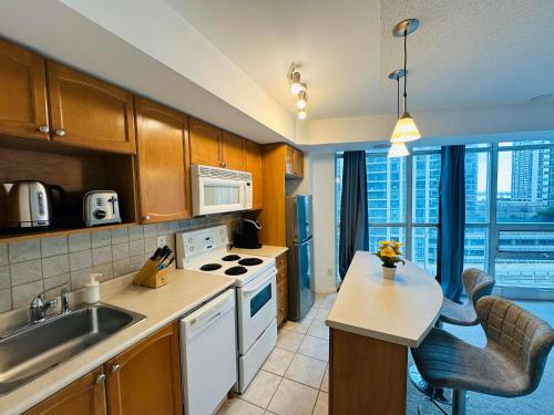 a kitchen with a sink and a stove top oven at The Yonge Suites in Toronto