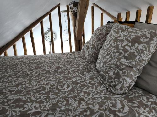 - un lit avec une couette grise et blanche sur un escalier dans l'établissement La maison du lavoir, à Ballan-Miré
