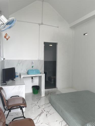 a bedroom with a bed and a desk and a chair at Minamo Homestay Modern Tengah Kota Payakumbuh in Payakumbuh