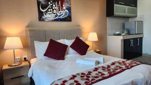 a bedroom with a bed with two towels on it at The Viana Apartment 1 in Kota Bharu