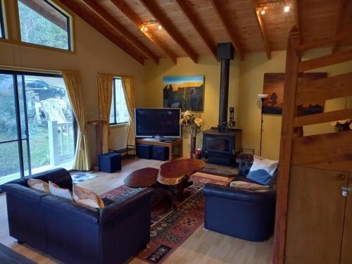 a living room with two couches and a television at Grampians Trail Cottage in Halls Gap