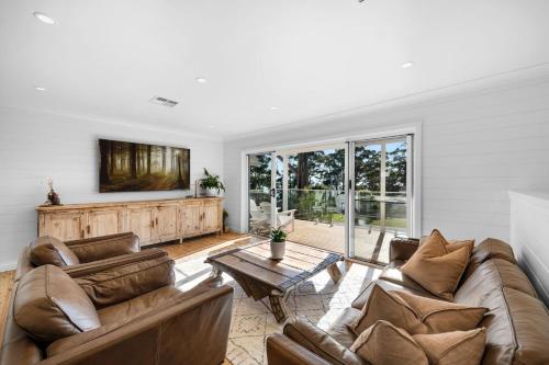 a living room with two couches and a table at "Casa di Mare=" House by the Sea - Belle Escapes Jervis Bay in Vincentia