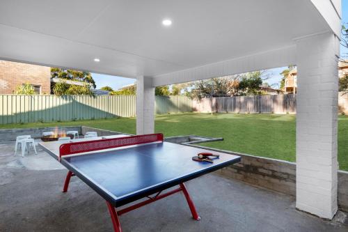 a ping pong table in the middle of a patio at "Casa di Mare=" House by the Sea - Belle Escapes Jervis Bay in Vincentia