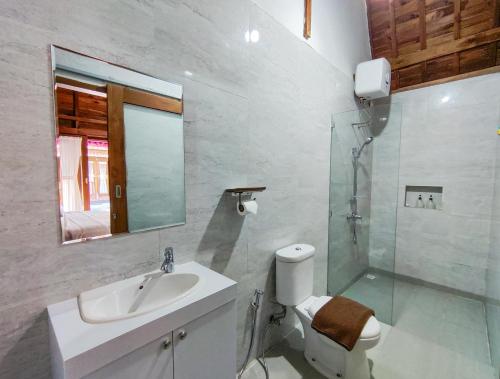 a bathroom with a sink and a toilet and a mirror at Aming Villa Balangan in Jimbaran