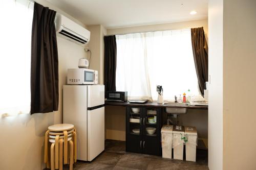a kitchen with a refrigerator and a counter with a window at Hanarai Asakusa in Tokyo