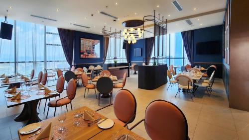 a restaurant with tables and chairs and windows at Imperial Lexis Kuala Lumpur in Kuala Lumpur