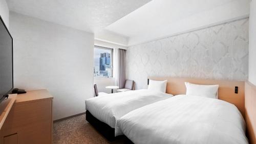a bedroom with a large white bed and a window at Daiwa Roynet Hotel Kawasaki in Kawasaki