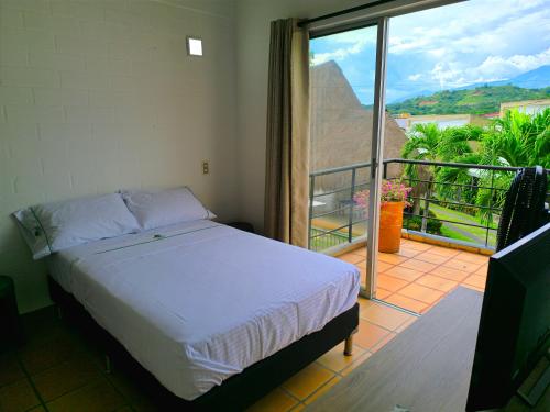 a bedroom with a bed and a balcony with a view at Casa Premium Las Palmas San Jeronimo in San Jerónimo