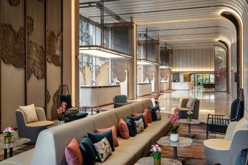 a lobby with a long couch with colorful pillows at Imperial Lexis Kuala Lumpur in Kuala Lumpur