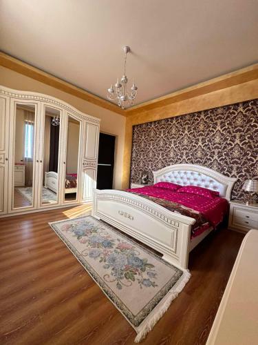 a bedroom with a white bed with a red bedspread at ABO in Yerevan
