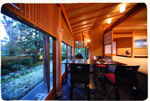 a dining room with a table and chairs in a house at 金沢湯涌温泉湯の出 in Kanazawa