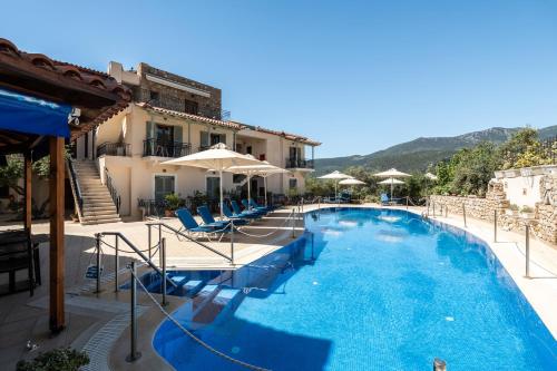 a pool at a hotel with chairs and umbrellas at Hotel Liakoto in Kardamili