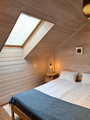 a bedroom with a large bed with a skylight at Vila Ambasada in Šventoji