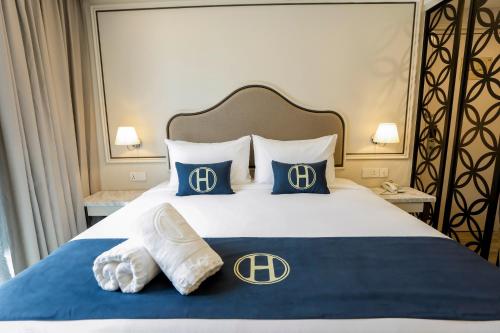 a bedroom with a bed with blue and white pillows at The Host Hotel in Ipoh