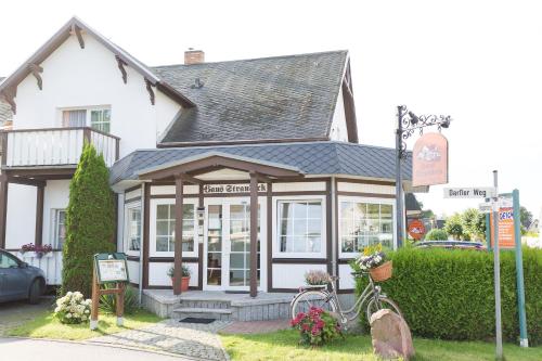 a small building with a sign in front of it at Haus Strandeck in Zingst