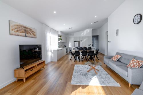 a living room with a couch and a tv at Luxury home away from home in Mickleham
