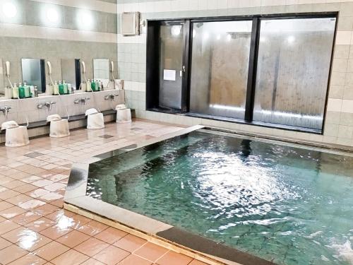 青森市にあるホテルルートイン青森駅前の洗面台付きのバスルーム(水のプール付)