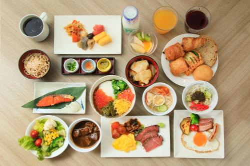 a table topped with plates of food and bowls of food at Richmond Hotel Morioka Ekimae in Morioka