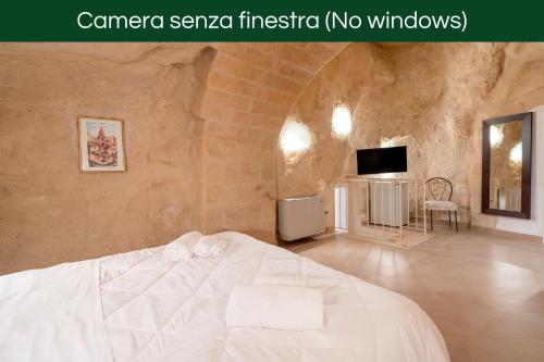 a bedroom with a white bed and a tv at Terrazze San Martino in Matera