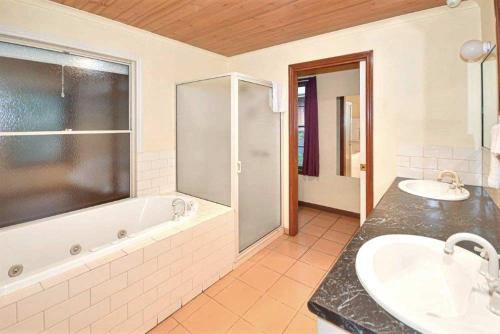 a bathroom with two sinks and a bath tub at Mountainside Villas Halls Gap in Halls Gap