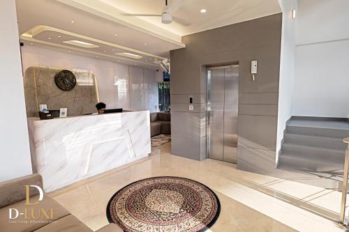 a lobby with a reception desk and a rug at D-Luxe Hotel in Ernakulam