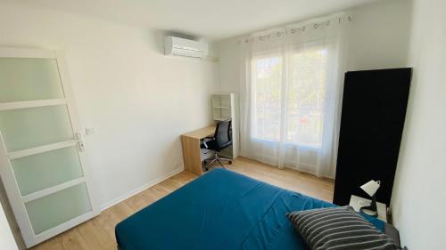 une chambre avec un lit bleu et une fenêtre dans l'établissement Joli 3pièces refait à neuf et très bien situé, à Cannes