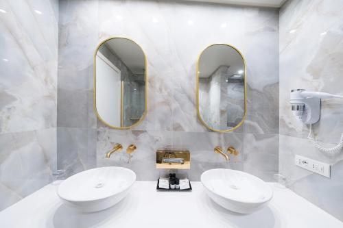 a bathroom with two sinks and two mirrors at Borgo Le Terrazze in Bellagio
