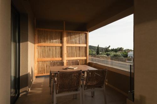 a table and chairs in a room with a window at Pournari Mountain Rooms in Toroni