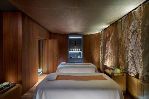 a row of beds in a room with a room with a kitchen at Mandarin Oriental, Milan in Milan