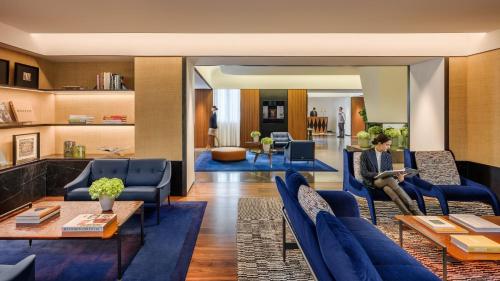 a man sitting on a couch in a living room at Mandarin Oriental, Milan in Milan