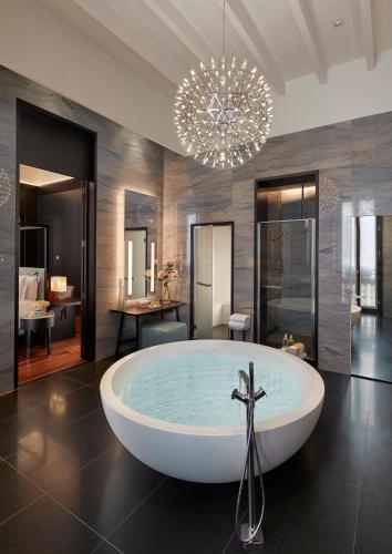 a large bathroom with a bath tub and a chandelier at Mandarin Oriental, Milan in Milan