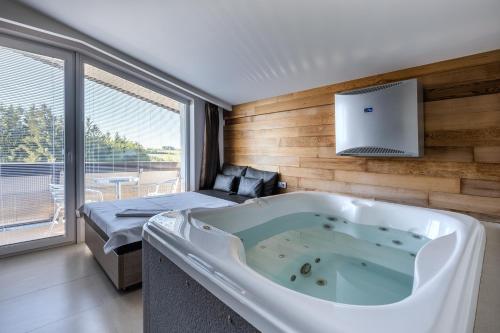 duża wanna w pokoju z łóżkiem w obiekcie Hotel Jezerka w mieście Seč