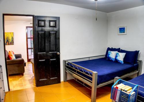 a bedroom with a bed with blue sheets and a door at The Beach Pad Puntas in Rincon