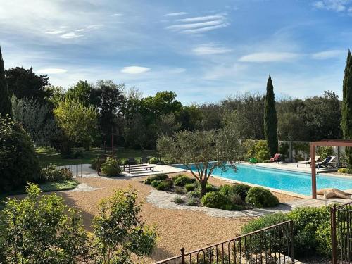 a swimming pool in a garden with a fence at Gite Monet in Bouchet