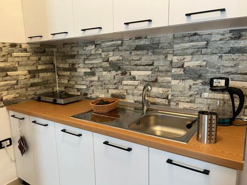 a kitchen with a sink and a brick wall at Asja's Apartment Vlore in Vlorë