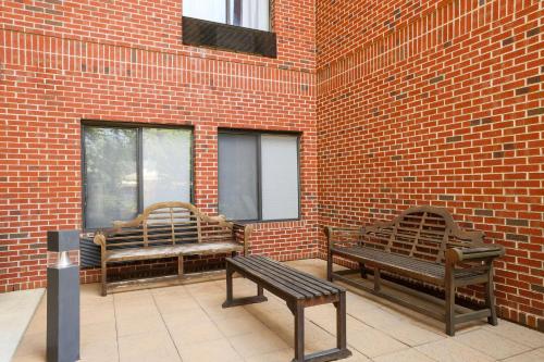 two benches sitting in front of a brick wall at Holiday Inn Express Hotel & Suites Wake Forest - Raleigh North by IHG in Wake Forest