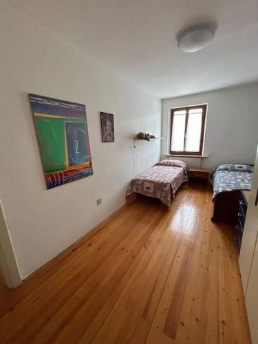 a room with white walls and a hard wood floor at Antica Dimora garden Alpe Adria cycle path in Pradamano