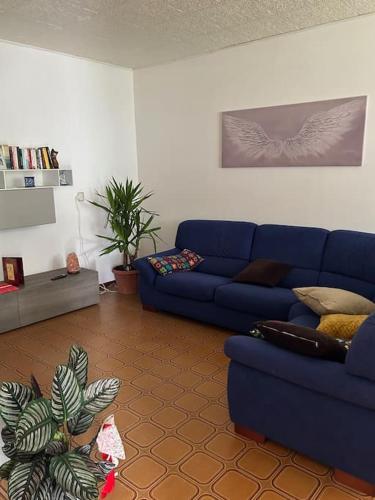 a living room with a blue couch and a plant at Antica Dimora garden Alpe Adria cycle path in Pradamano