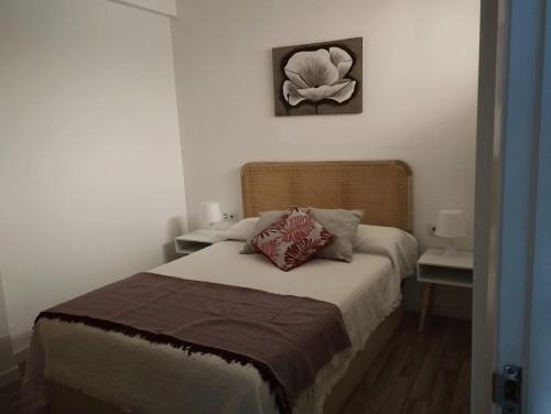 ein Schlafzimmer mit einem Bett mit einer Blume an der Wand in der Unterkunft Faro da Borneira in Cangas