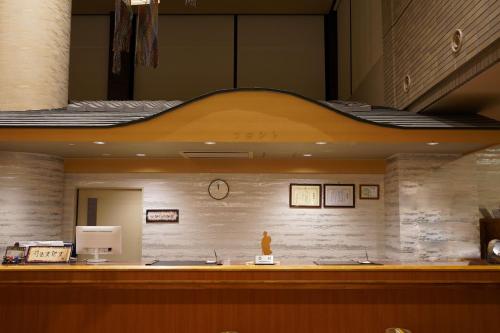 a lobby with a counter with a clock on the wall at Hill Hotel Sunpia Iga in Iga