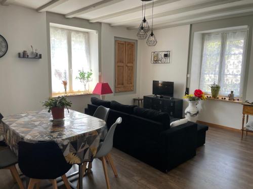 un salon avec une table et un canapé dans l'établissement Appartement ravissant en bordure du Doubs, à Longevelle-sur-Doubs
