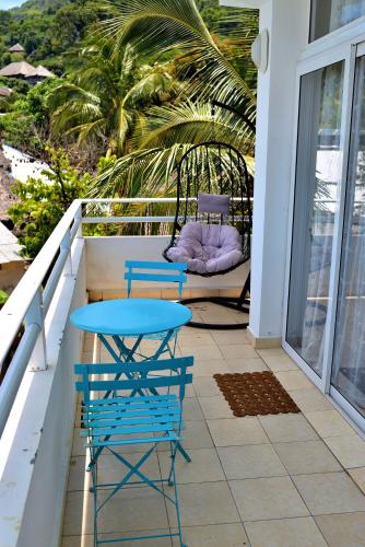 a patio with two chairs and a table on a balcony at Hôtel de rêve Nosy Komba in Nosy Komba