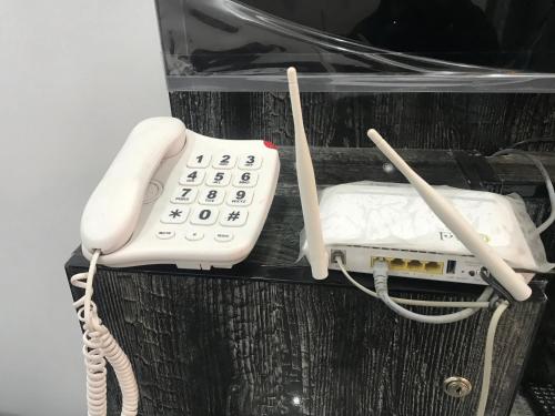 a white phone sitting on top of a shelf at Guest House in Jhelum